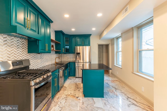 kitchen featuring dark countertops, appliances with stainless steel finishes, a sink, tasteful backsplash, and visible vents