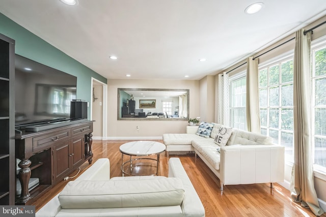 living room featuring recessed lighting, baseboards, and light wood-style floors
