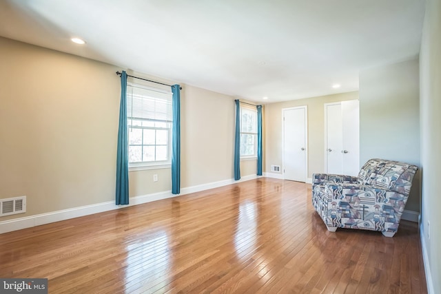 interior space with baseboards, recessed lighting, hardwood / wood-style floors, and visible vents
