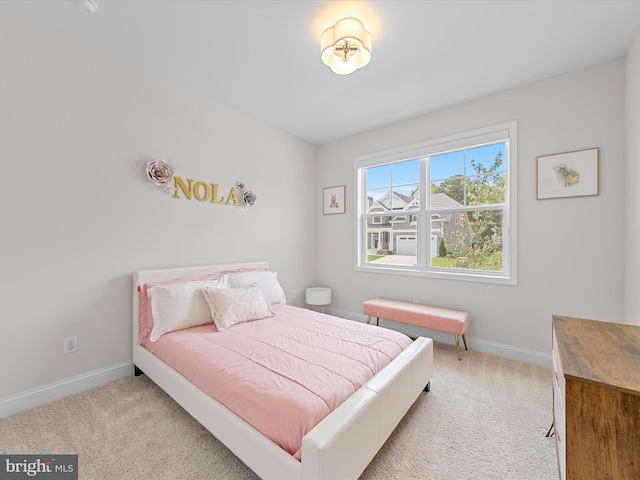 bedroom with baseboards and light colored carpet