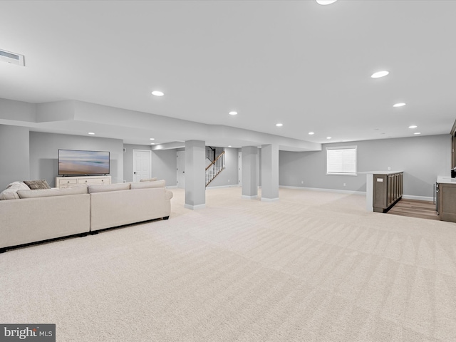 living area featuring recessed lighting, baseboards, visible vents, and light carpet