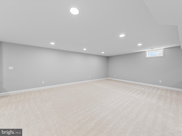 basement featuring baseboards, recessed lighting, and light colored carpet
