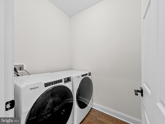 laundry area featuring baseboards, laundry area, wood finished floors, and washing machine and clothes dryer
