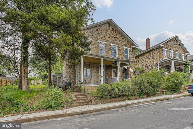 view of front of property featuring stone siding and covered porch