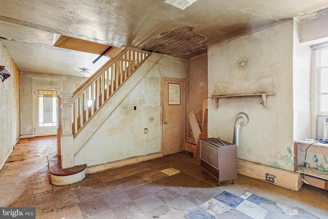 foyer entrance featuring stairway and stone finish flooring