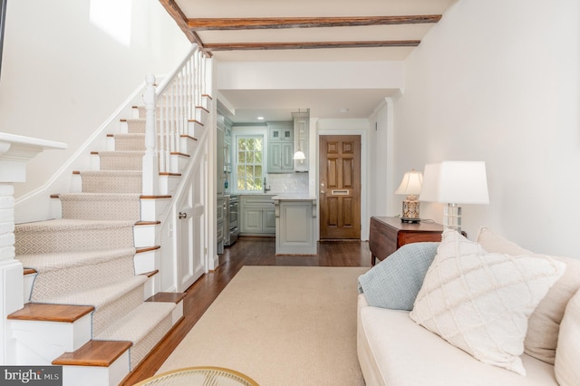 living room featuring dark wood-type flooring and stairs