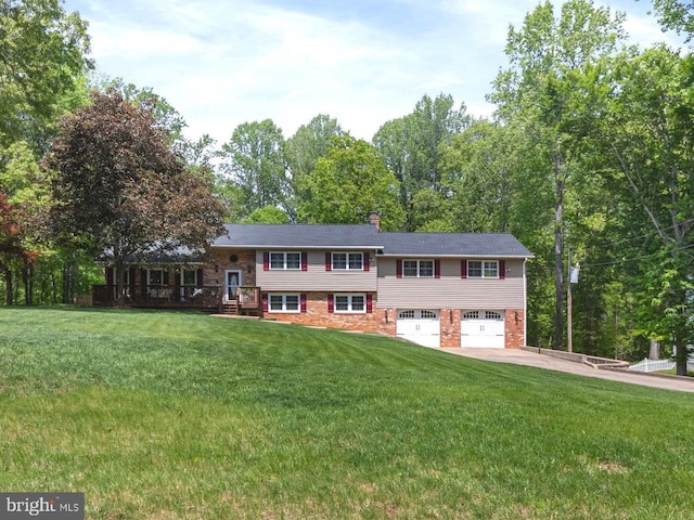 tri-level home with an attached garage, a chimney, driveway, and a front yard