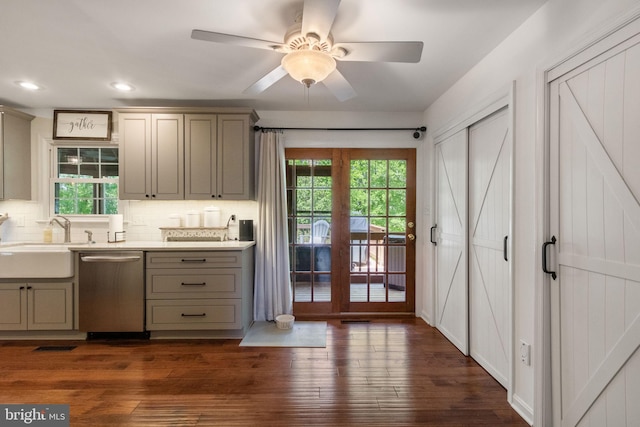 kitchen with a sink, gray cabinets, tasteful backsplash, and dishwasher