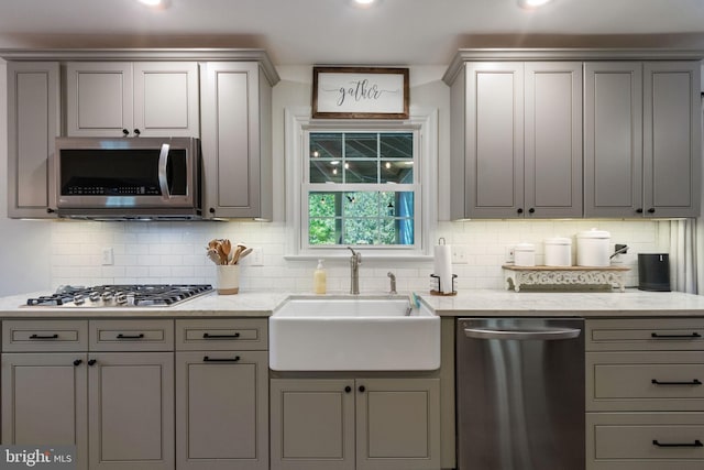 kitchen featuring gray cabinetry, appliances with stainless steel finishes, and a sink