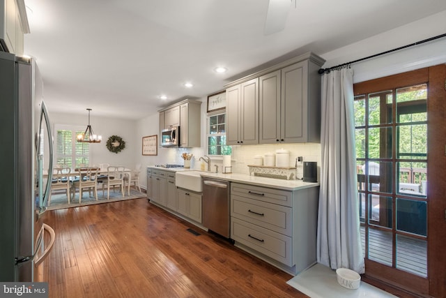 kitchen featuring a sink, gray cabinets, stainless steel appliances, and tasteful backsplash