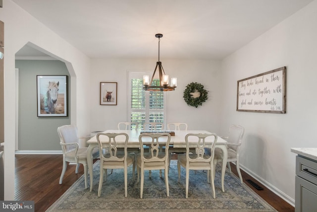 dining space featuring baseboards, visible vents, dark wood finished floors, and a notable chandelier