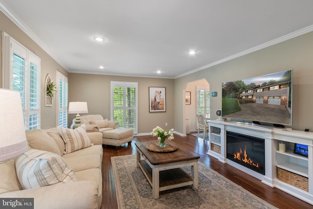 living area with crown molding, arched walkways, dark wood finished floors, recessed lighting, and baseboards
