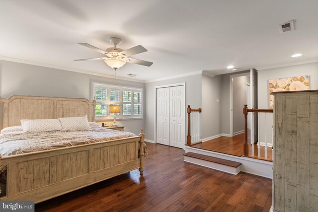 bedroom with ceiling fan, dark wood-style flooring, visible vents, crown molding, and a closet