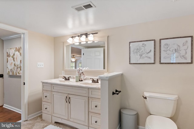 bathroom featuring a sink, toilet, double vanity, and visible vents