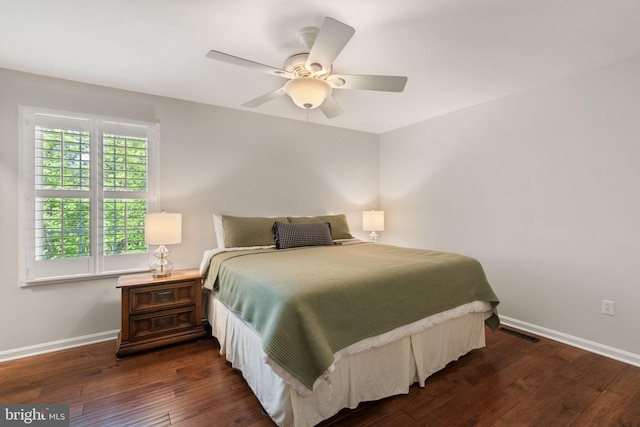 bedroom with a ceiling fan, baseboards, visible vents, and dark wood-type flooring