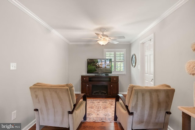 living area featuring crown molding, dark wood-style flooring, ceiling fan, and baseboards