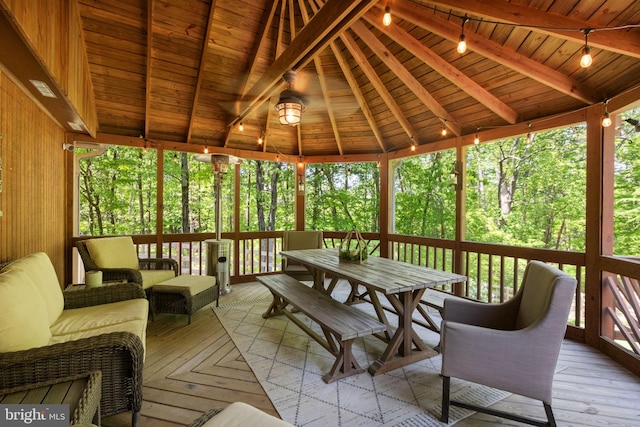 sunroom / solarium featuring track lighting, beam ceiling, and a wealth of natural light