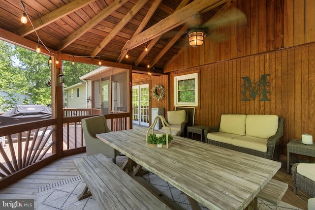 sunroom featuring beamed ceiling and outdoor dining space