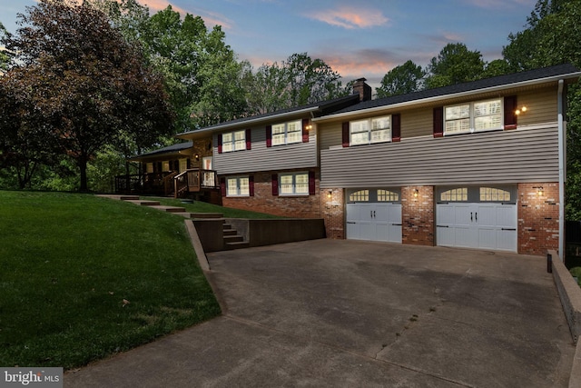 view of front facade with an attached garage, brick siding, a chimney, and concrete driveway