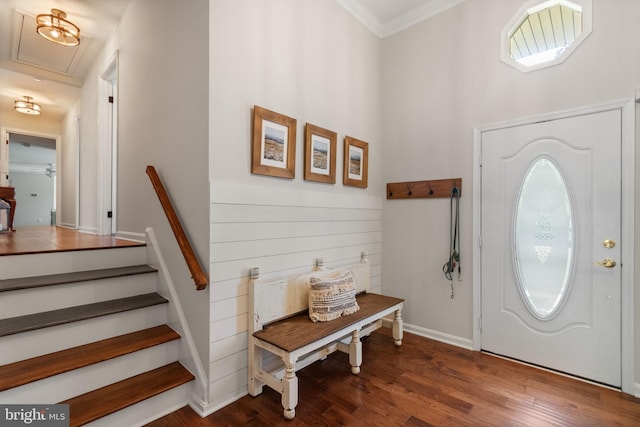 foyer entrance featuring crown molding, a high ceiling, baseboards, and wood finished floors
