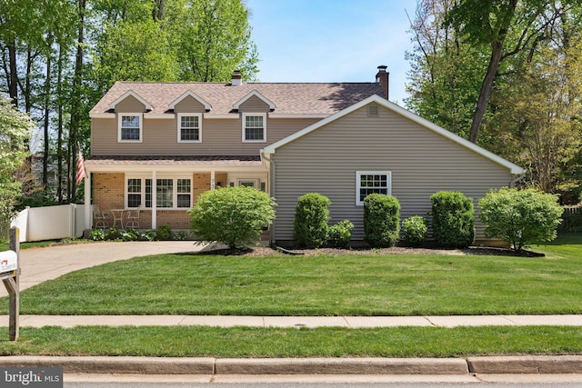 view of front of home with fence, a chimney, a shingled roof, and a front yard