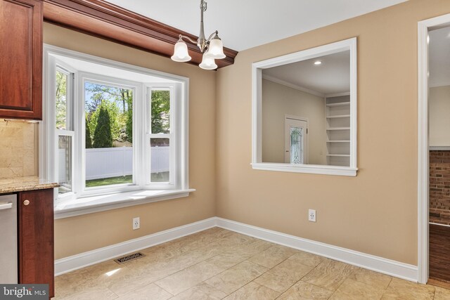 unfurnished dining area with an inviting chandelier, baseboards, ornamental molding, and visible vents