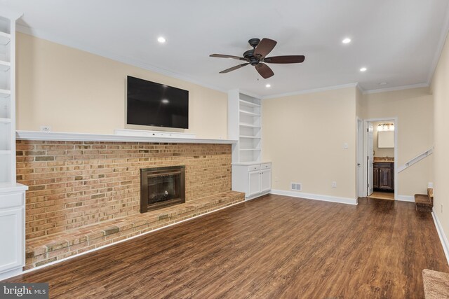 unfurnished living room with ceiling fan, crown molding, a fireplace, dark wood finished floors, and recessed lighting