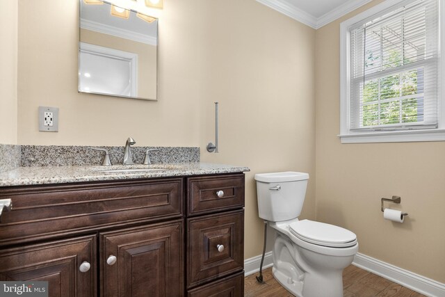 half bathroom featuring toilet, baseboards, ornamental molding, and wood finished floors