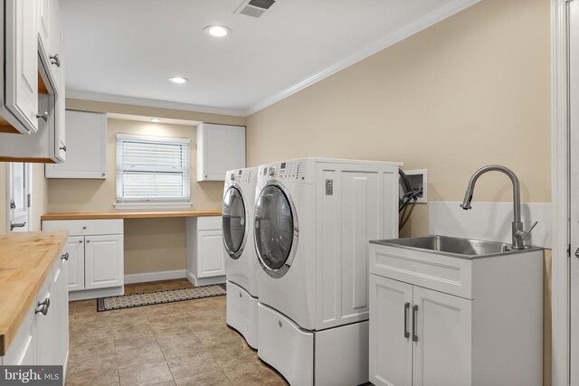 laundry area with visible vents, crown molding, cabinet space, a sink, and washer and clothes dryer