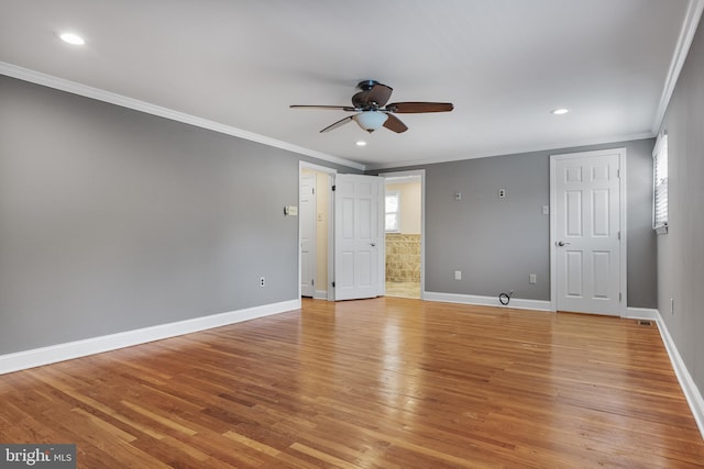 spare room with a ceiling fan, baseboards, ornamental molding, and light wood-style flooring