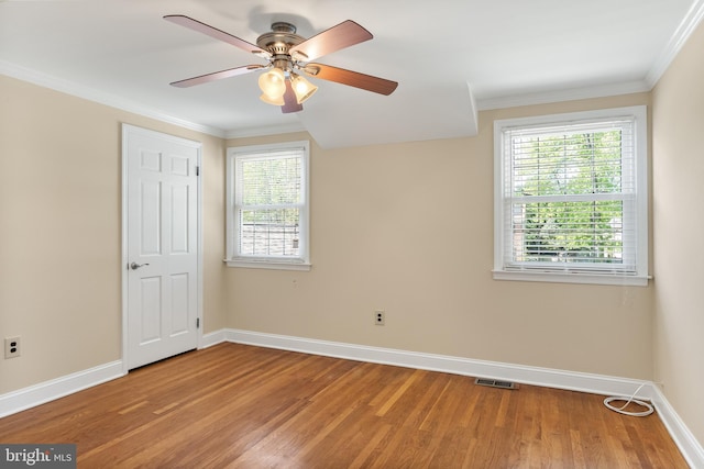 unfurnished bedroom featuring a ceiling fan, visible vents, crown molding, baseboards, and light wood-style floors