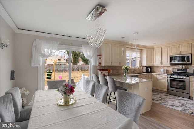 dining room featuring an inviting chandelier, light wood-style flooring, and crown molding
