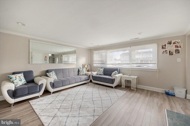 living area with baseboards, ornamental molding, light wood-style floors, and visible vents