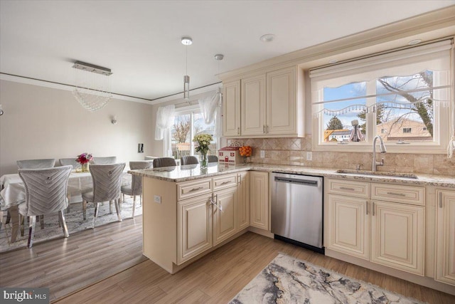 kitchen featuring a sink, tasteful backsplash, dishwasher, and cream cabinetry