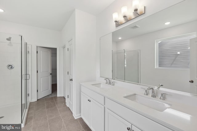 bathroom featuring double vanity, a sink, and a stall shower