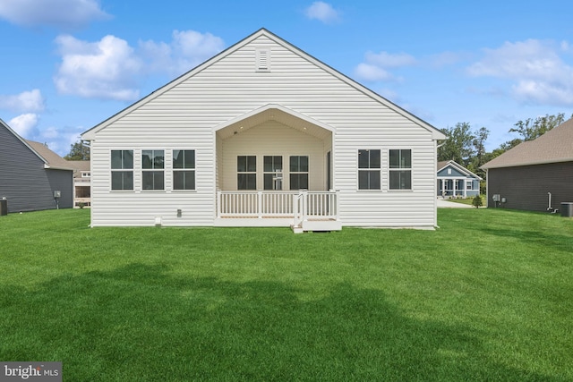 rear view of house with a lawn and central AC
