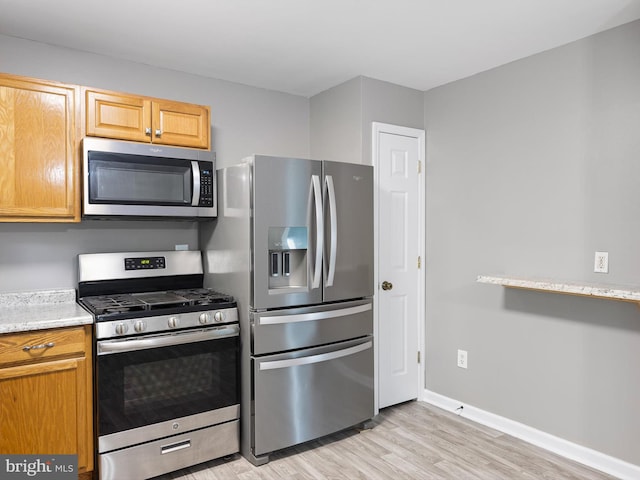 34 Dovetree Dr, Newark, DE 19713 - kitchen featuring stainless steel appliances, light wood-style flooring, baseboards, and light stone countertops