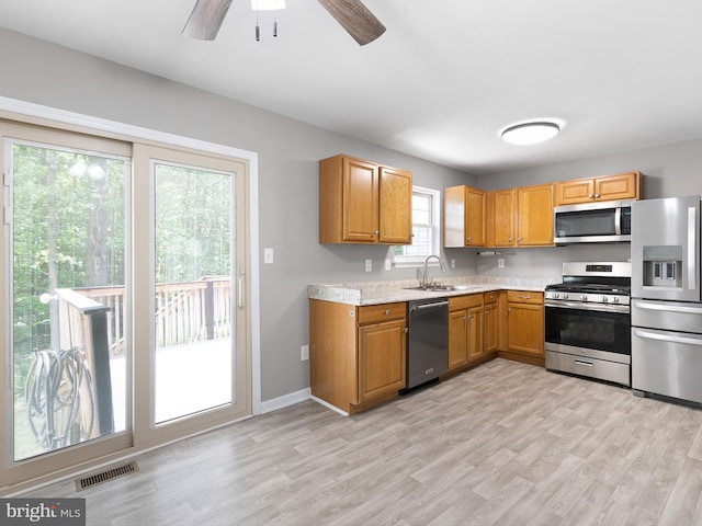 34 Dovetree Dr, Newark, DE 19713 - kitchen with stainless steel appliances, a sink, light countertops, ceiling fan, and light wood-type flooring