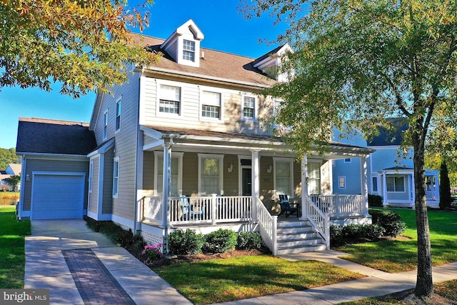 view of front facade with a garage, a front lawn, roof with shingles, a porch, and driveway