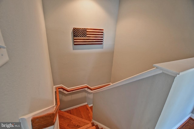 stairway with baseboards and wood finished floors
