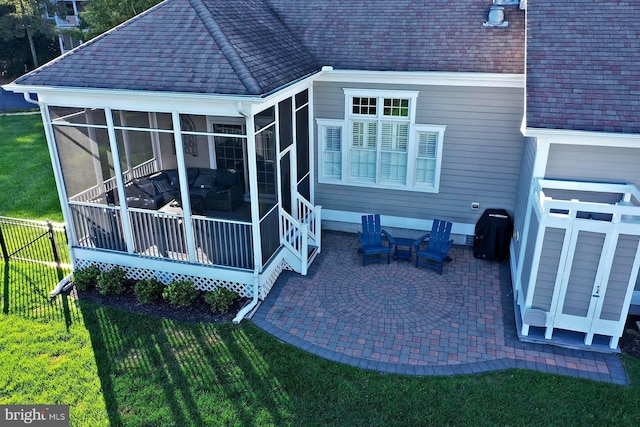 back of house with roof with shingles, fence, a sunroom, a patio area, and a lawn