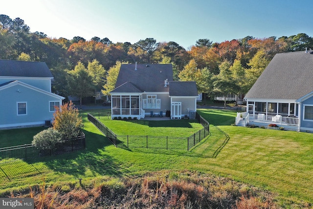 back of house with a sunroom, a fenced backyard, central air condition unit, and a yard