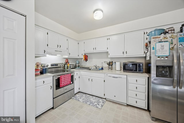 kitchen featuring light countertops, white cabinetry, under cabinet range hood, a sink, and appliances with stainless steel finishes