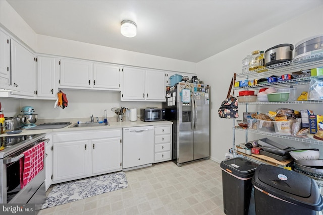 kitchen featuring white cabinets, a sink, light countertops, stainless steel appliances, and light floors