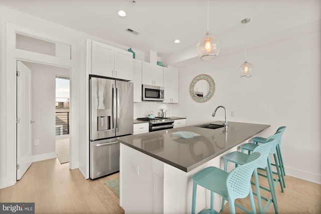 4016 Georgia Ave NW Unit 9, Washington, DC 20011 - kitchen with visible vents, decorative backsplash, a breakfast bar, a sink, and appliances with stainless steel finishes