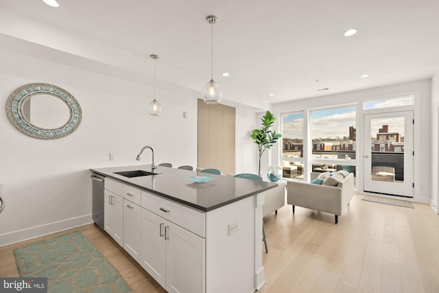 4016 Georgia Ave NW Unit 9, Washington, DC 20011 - kitchen featuring stainless steel dishwasher, a peninsula, white cabinetry, a sink, and light wood-style flooring
