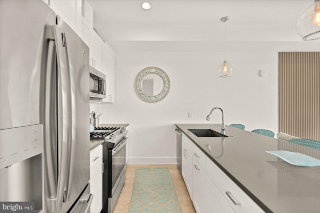 4016 Georgia Ave NW Unit 9, Washington, DC 20011 - kitchen with dark countertops, baseboards, white cabinets, a sink, and stainless steel appliances