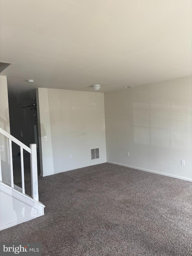 spare room with visible vents, carpet, and baseboards