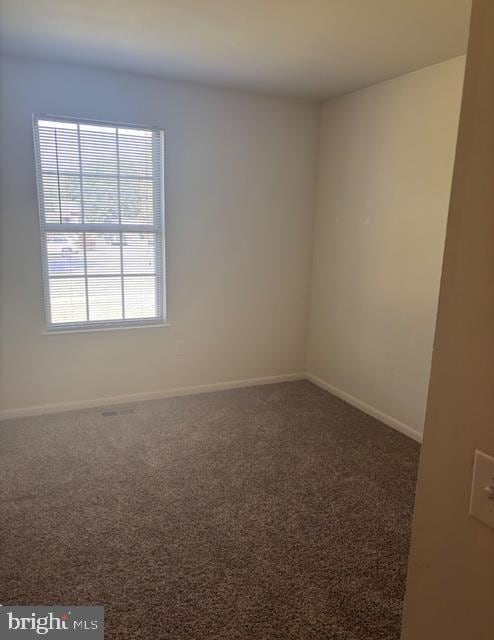 carpeted spare room with baseboards