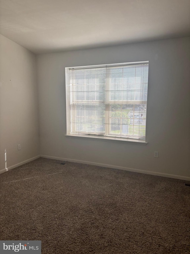 spare room featuring baseboards and carpet floors